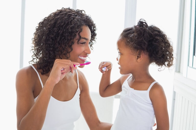 Mother and Daughter Brushing Teeth - Dentistry For Children