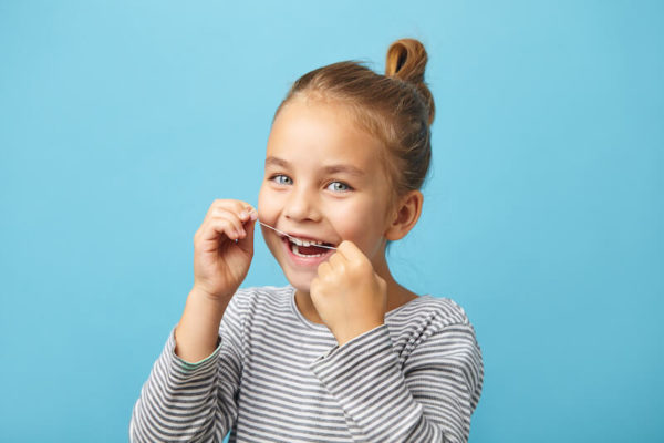a girl flossing her teeth